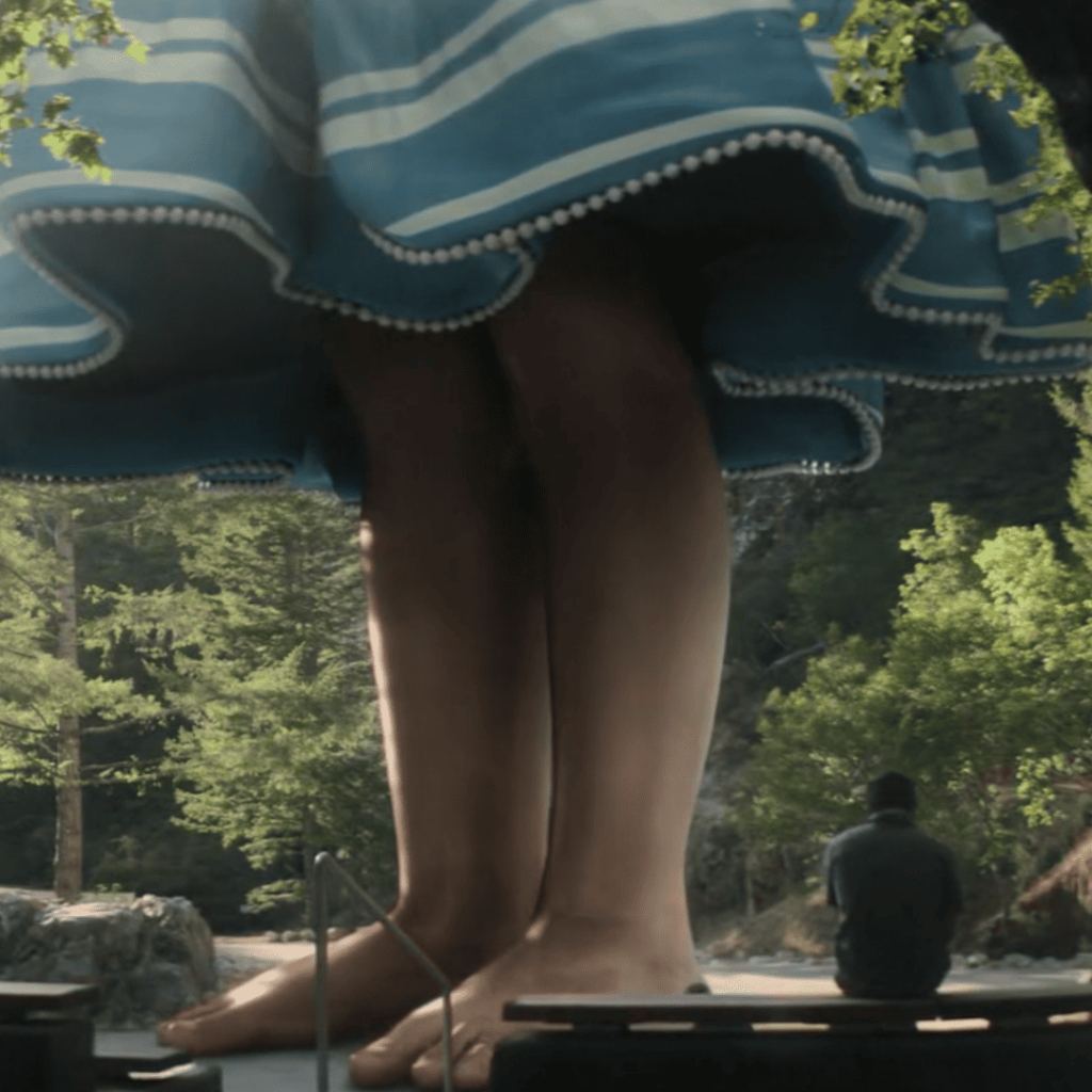 Devs: the feet of a person in a blue dress are on top of a rock