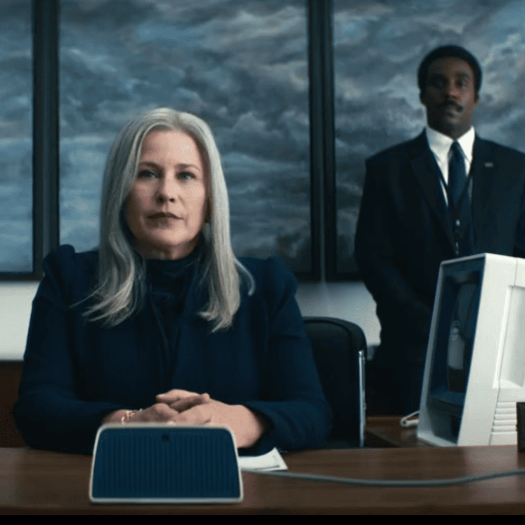 Sci Fi Series Like Tomorrow & I: Severance - A person sitting at a desk with a person behind them