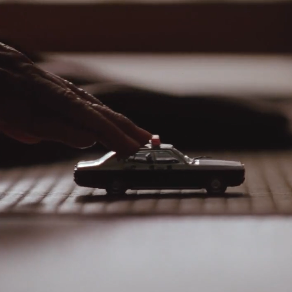 Asura Episode 1 - a close up of a toy police car on a table