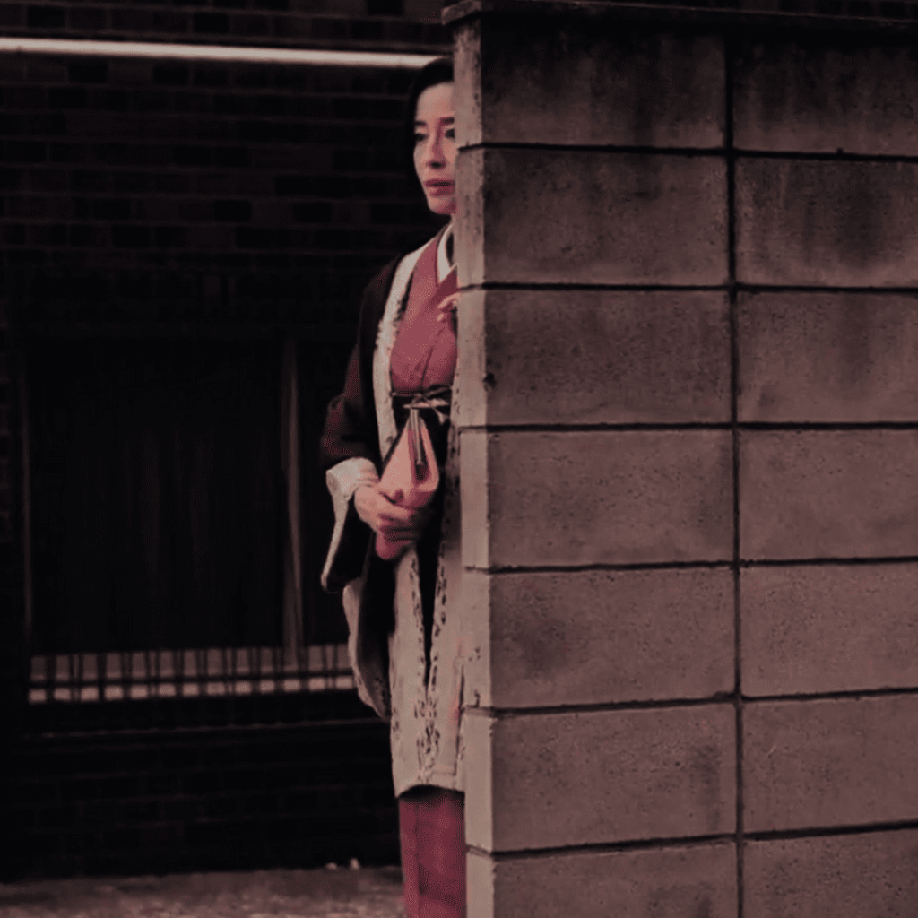 Asura Episode 1 - a person in kimono standing next to a brick wall