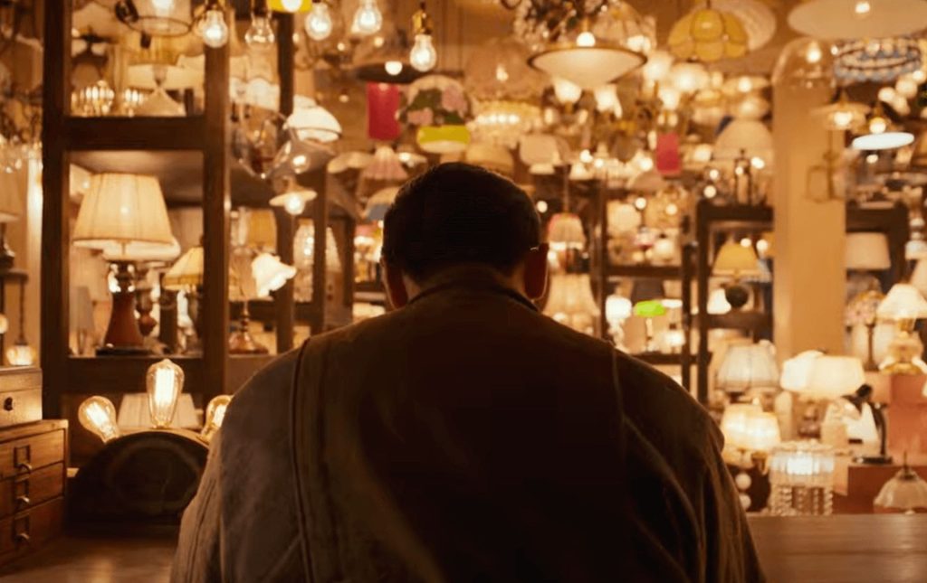 Light Shop K- Drama: a person sitting at a table in a room full of lamps