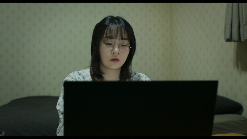 Light Shop  K-Drama: A person in glasses sitting in front of a laptop.