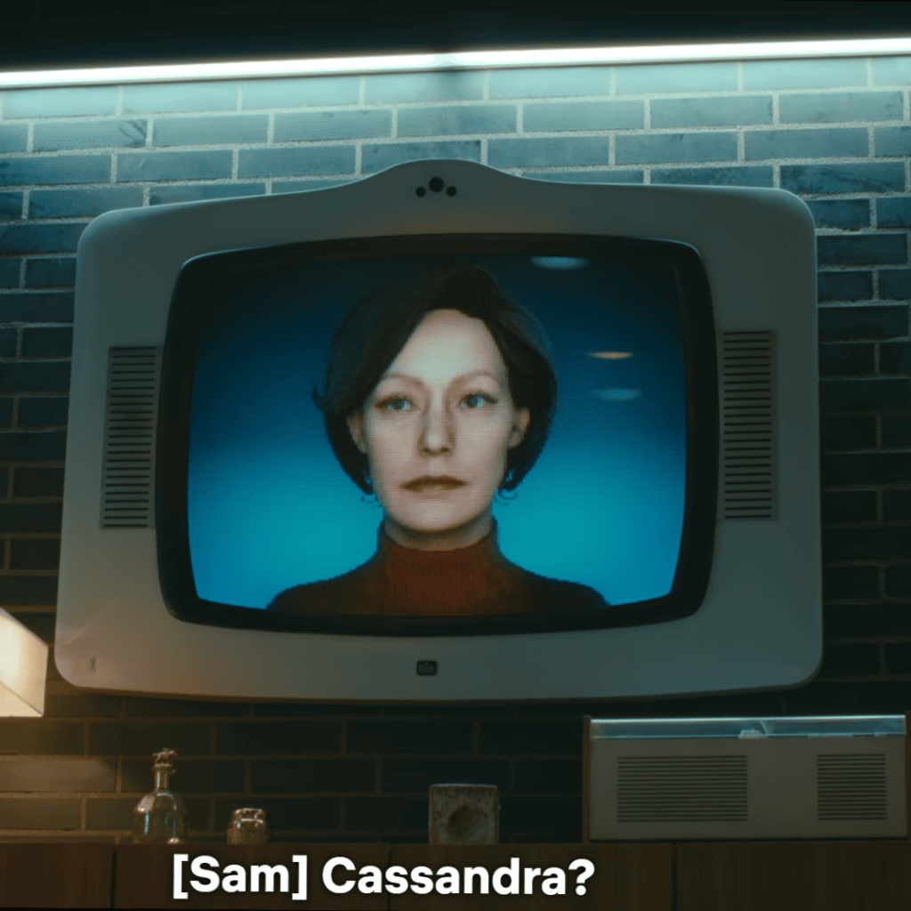 Cassandra Netflix Review: a robot stands in front of a television in a room