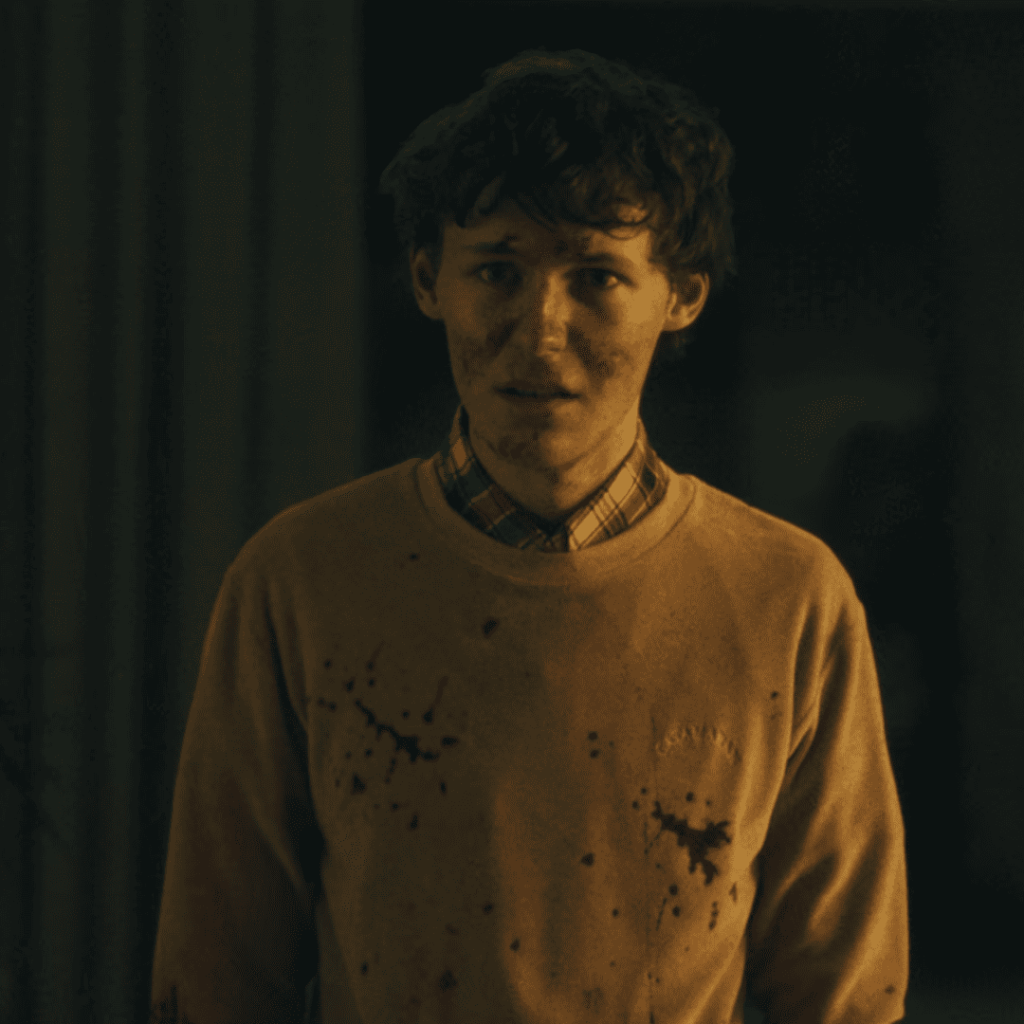 Cassandra Netflix Review: A person in a yellow sweater with blood on their face.