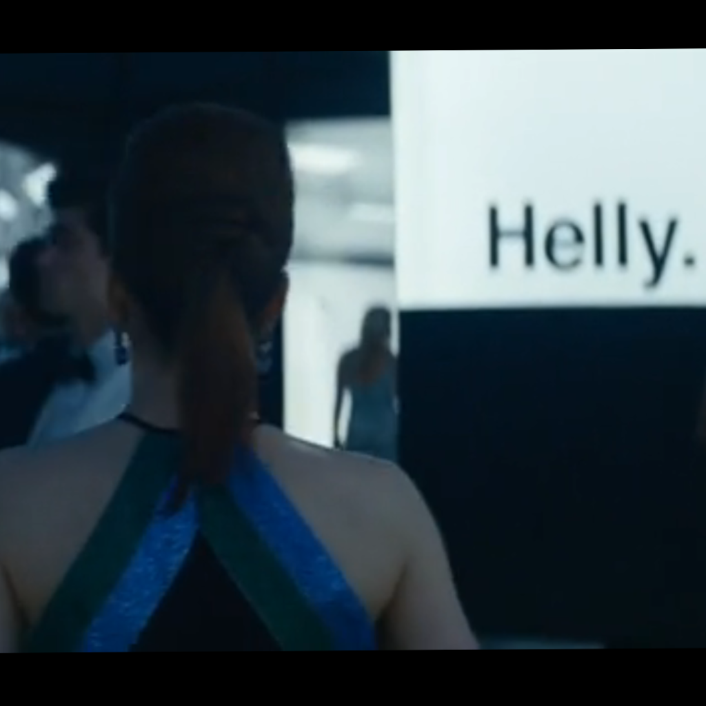 Severance Season 1 Ending Explained: a person in a blue dress standing in front of a sign that says Helly