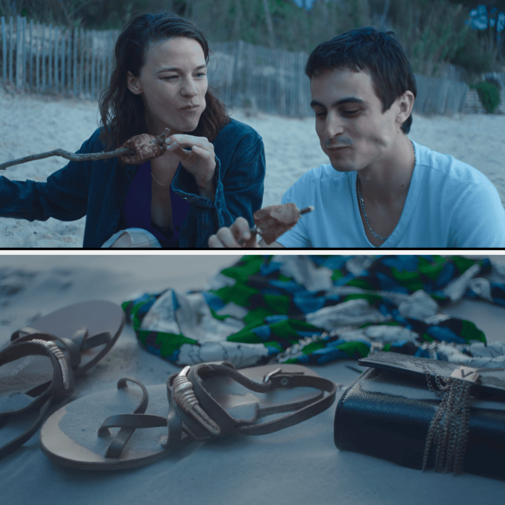 A couple sitting on the beach eating food.