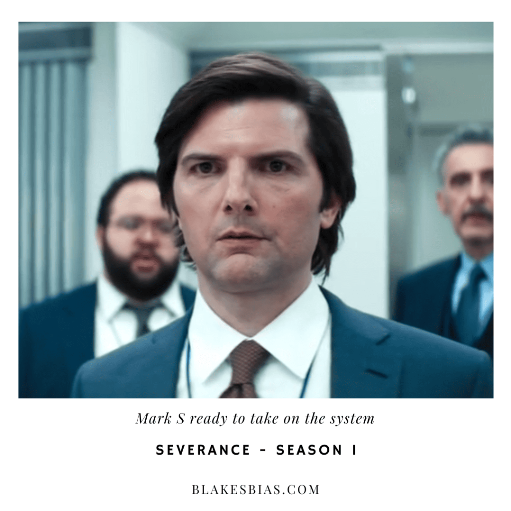 Best Severance Characters: A person in a suit and tie standing next to other people.