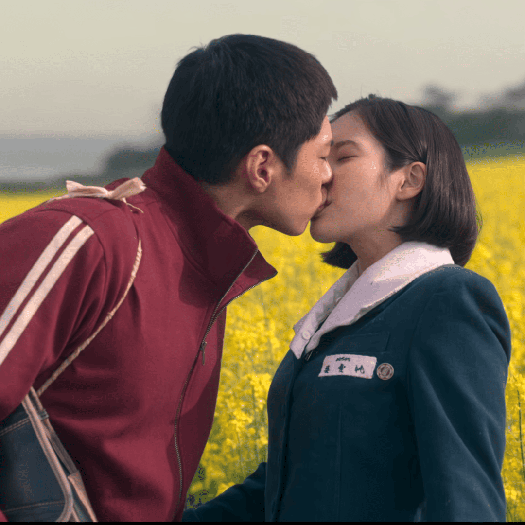 When Life Gives You Tangerines Review: A couple kissing in front of a field of yellow flowers.