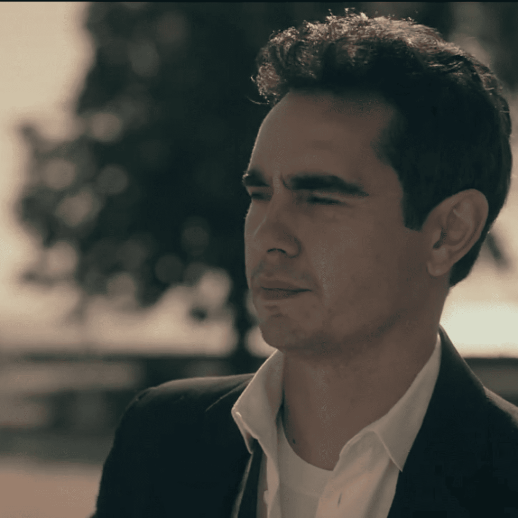 A man in a suit squints into the distance, his face worn with fatigue and quiet determination in Handmaid’s Tale Season 6.