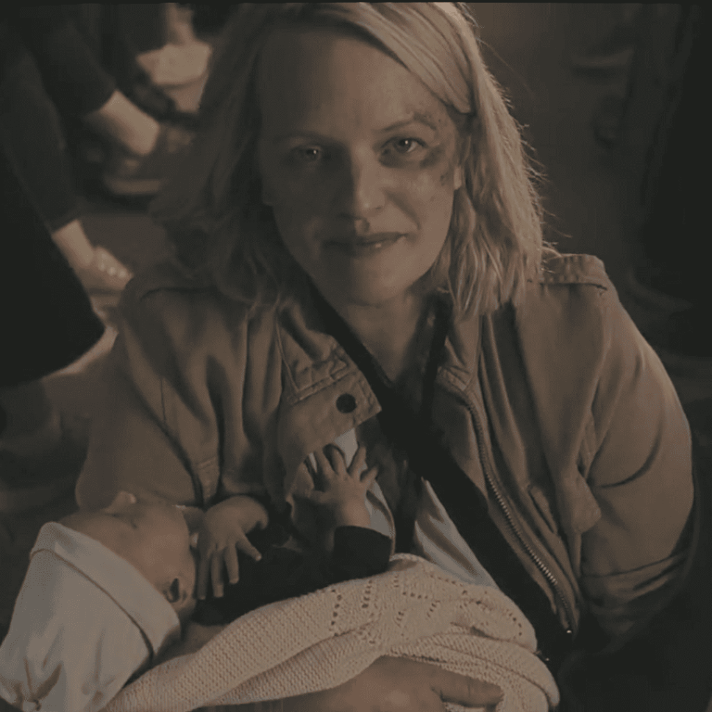 June cradles a baby, bruised but unbroken, in a quiet moment of defiance in Handmaid's Tale Season 6.