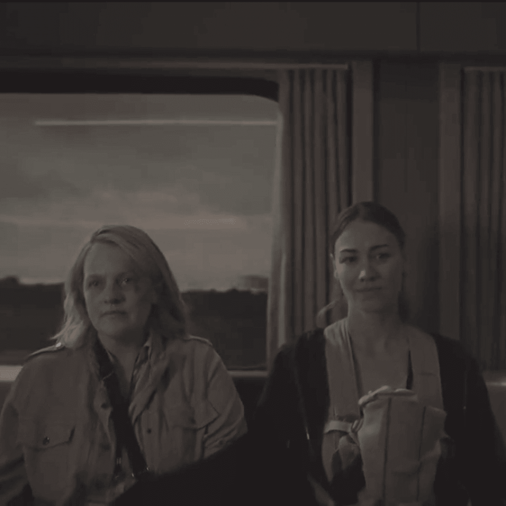 June and Serena ride silently side by side on a train, both appearing emotionally exhausted, in Handmaid's Tale Season 6.
