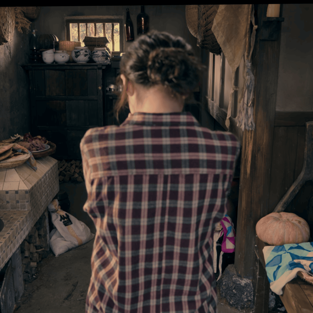 When Life Gives You Tangerines Full Review: A person in a plaid shirt standing in a kitchen.