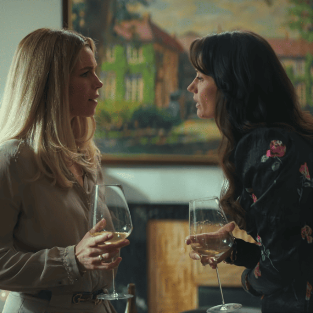 Cecile and Katarina exchange a loaded glance over wine in Secrets We Keep