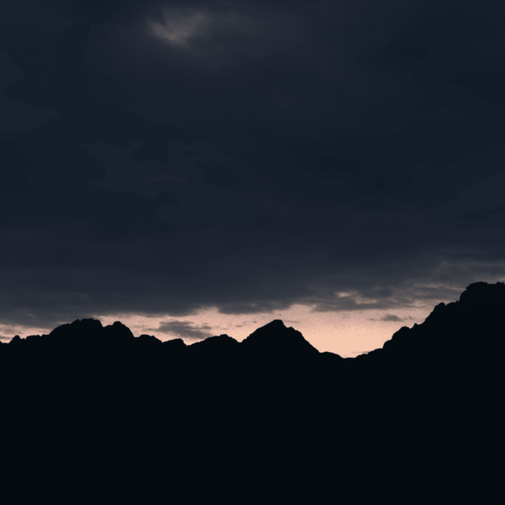 American Primeval Review: Dusk settles over wild mountain terrain, echoing the brutal beauty of American Primeval.

