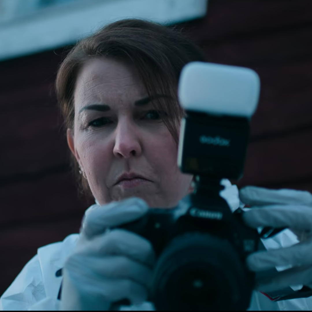 Glass Dome Review: A crime scene investigator takes a shot with their camera, capturing crucial evidence