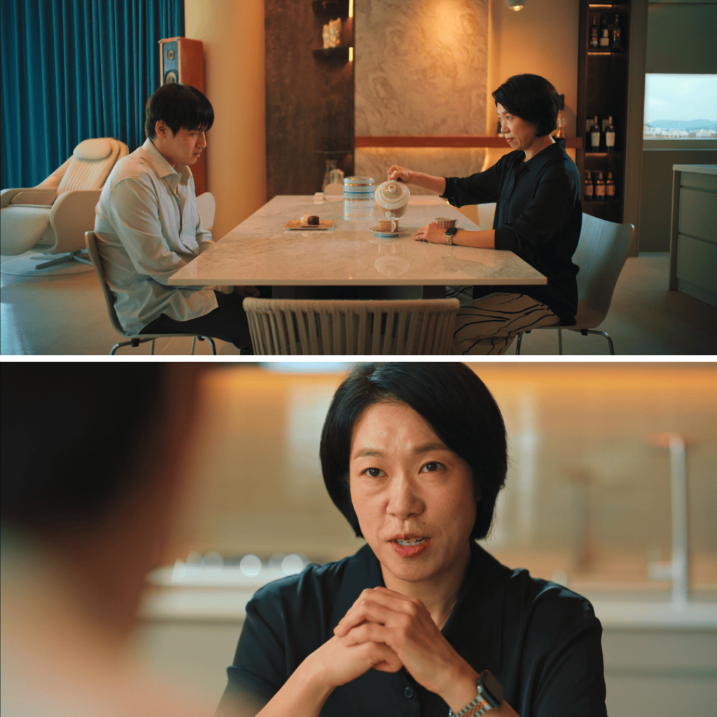 Two characters sit tensely across a table in Wall to Wall Movie Review.