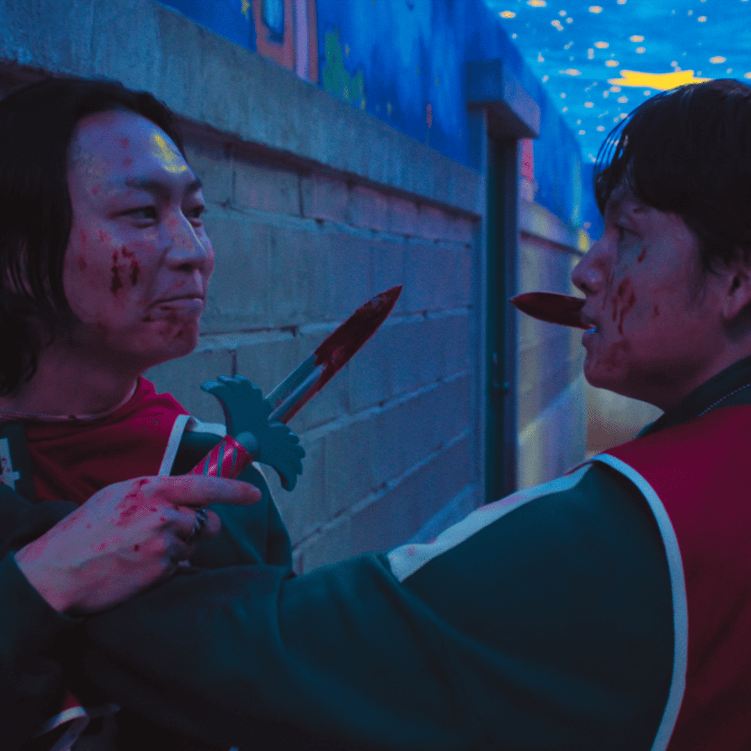 Two bloodied contestants under a starry ceiling in Squid Game 3 finale