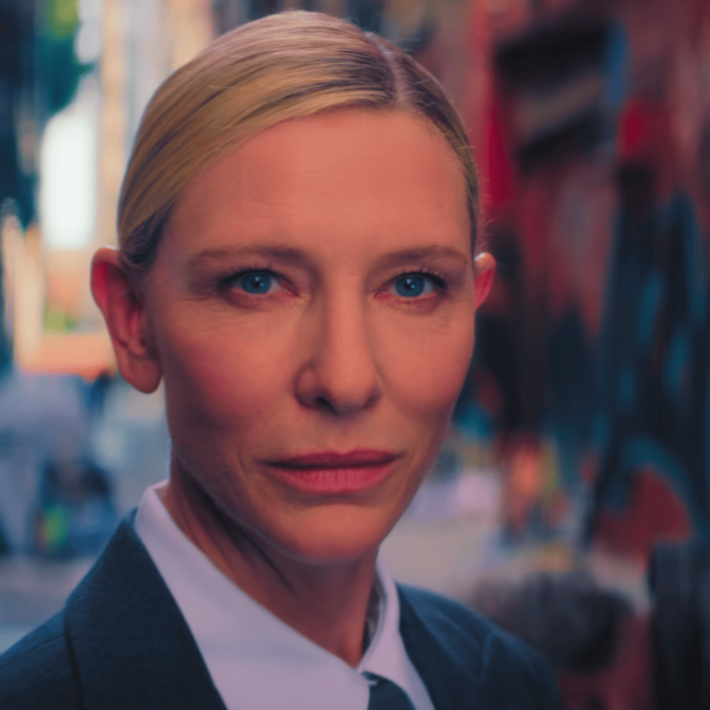 A serious-looking person in a suit and white shirt stands in a blurred urban alleyway, staring intently into the camera in Squid Game 3.