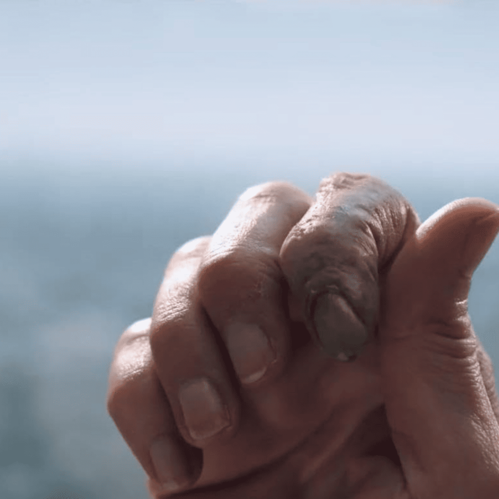 The Substance movie explained through a haunting close-up: Elizabeth Sparkle’s hand with a decaying finger, symbolizing the grotesque toll of Sue’s relentless consumption—blood and flesh corroded by final humiliation.