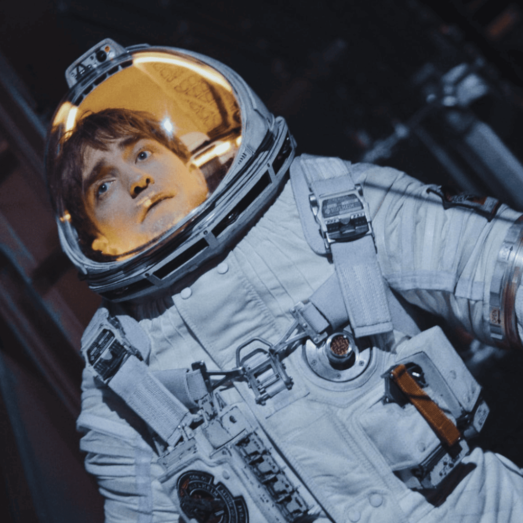 Robert Pattinson in full space suit and helmet, looking uncertain in Mickey 17.