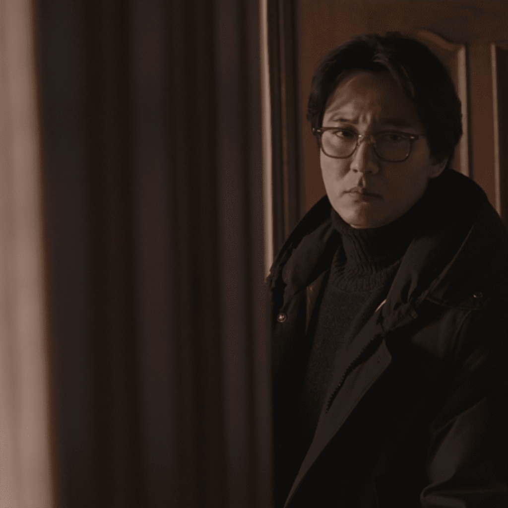 Nocturnal Movie Review close-up of Kim Nam-gil standing in a doorway, embodying intensity despite the weak script.