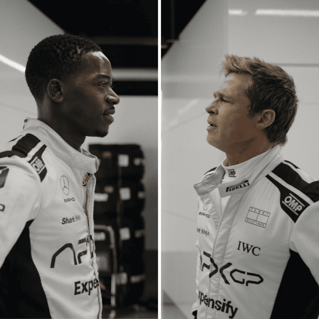 Brad Pitt and Damson Idris standing face to face in an F1 movie review still.