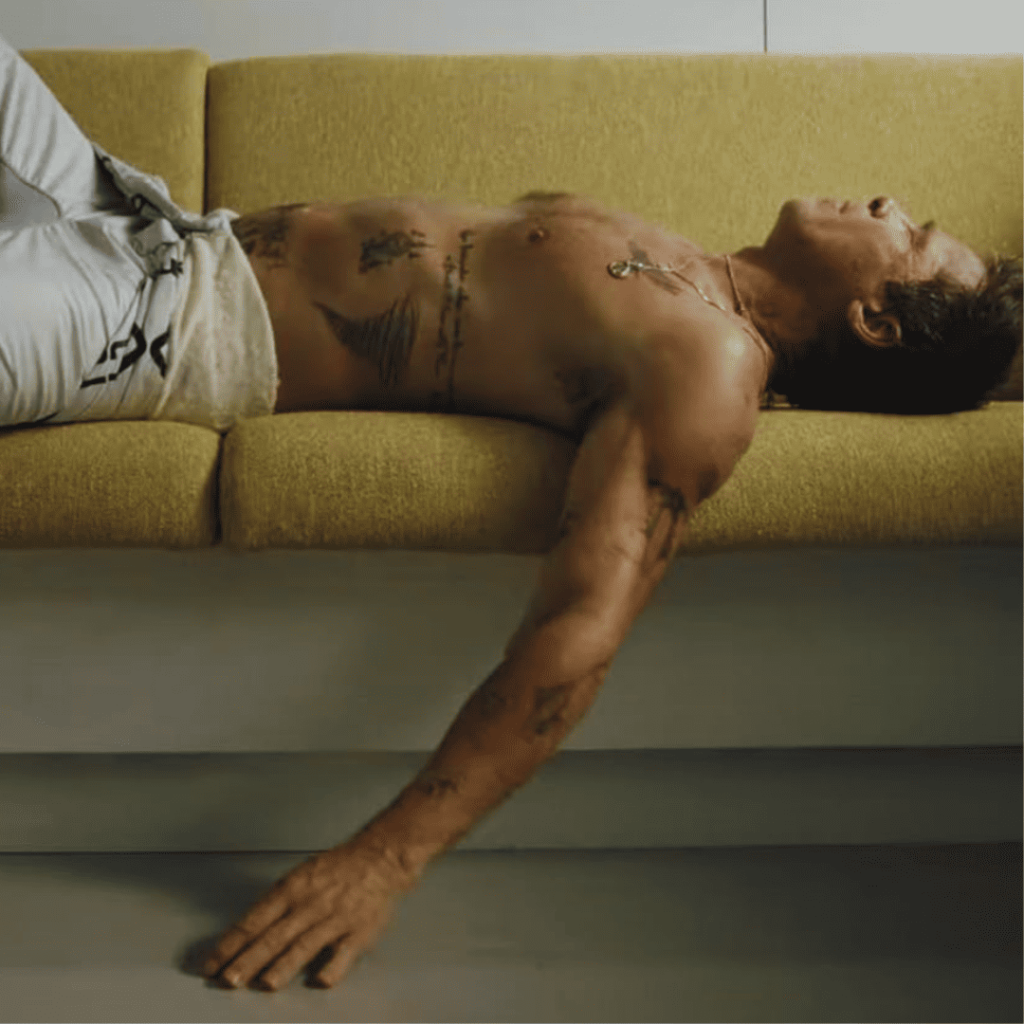 Brad Pitt reclining on golden couch for the F1 movie review verdict.