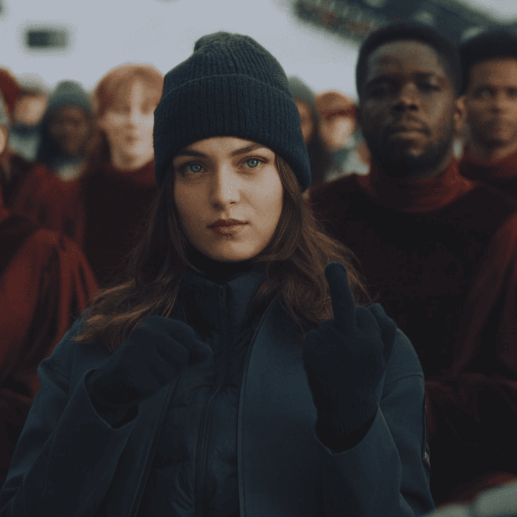  Kai Katz flipping the bird while wearing black gloves in Mickey 17.