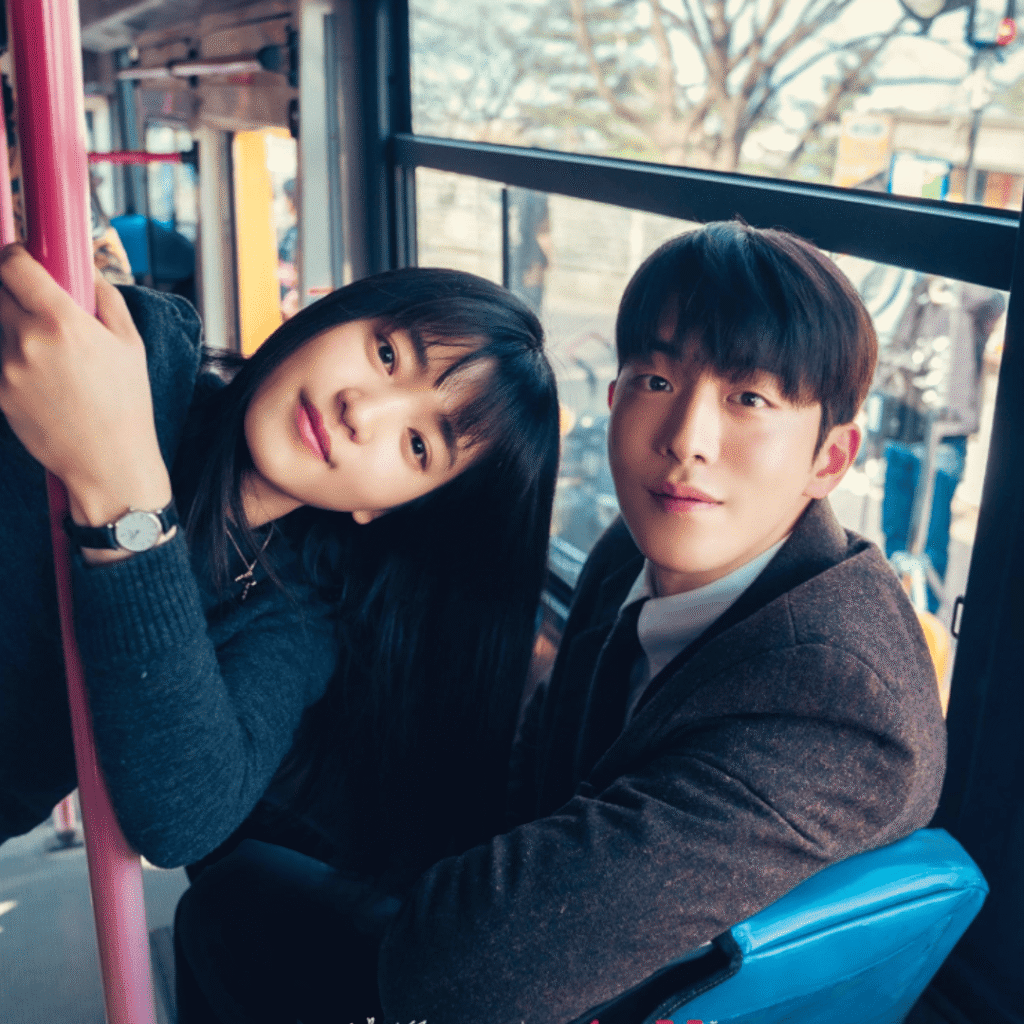 Twenty-Five, Twenty-One TvN image of Kim Tae-ri and Nam Joo-hyuk sitting on a bus, looking at the camera, capturing youthful nostalgia found in Kdramas like You and Everything Else