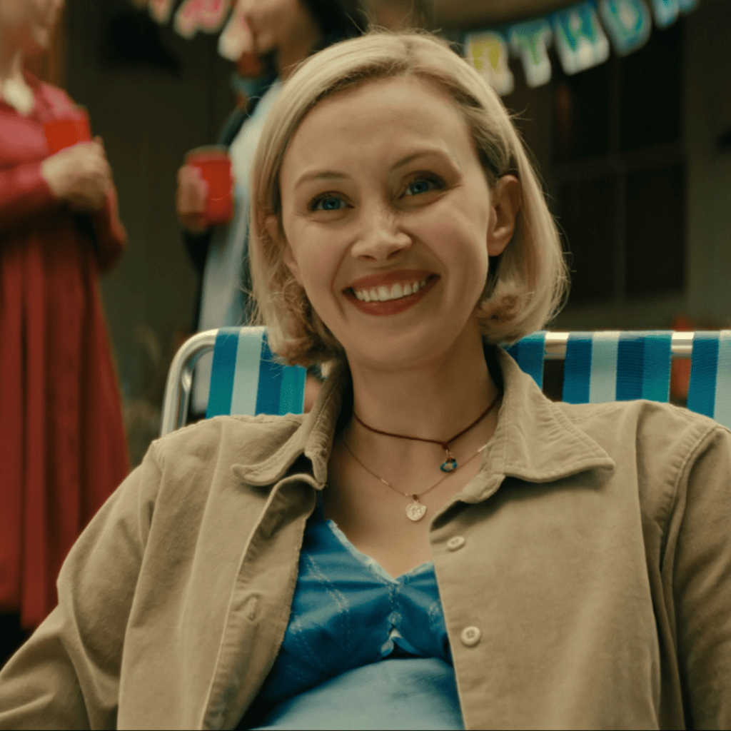 Close-up of Laura sitting in a deck chair, smiling, a quiet moment suggesting the fragility of healing and choice. | Wayward Netflix Review