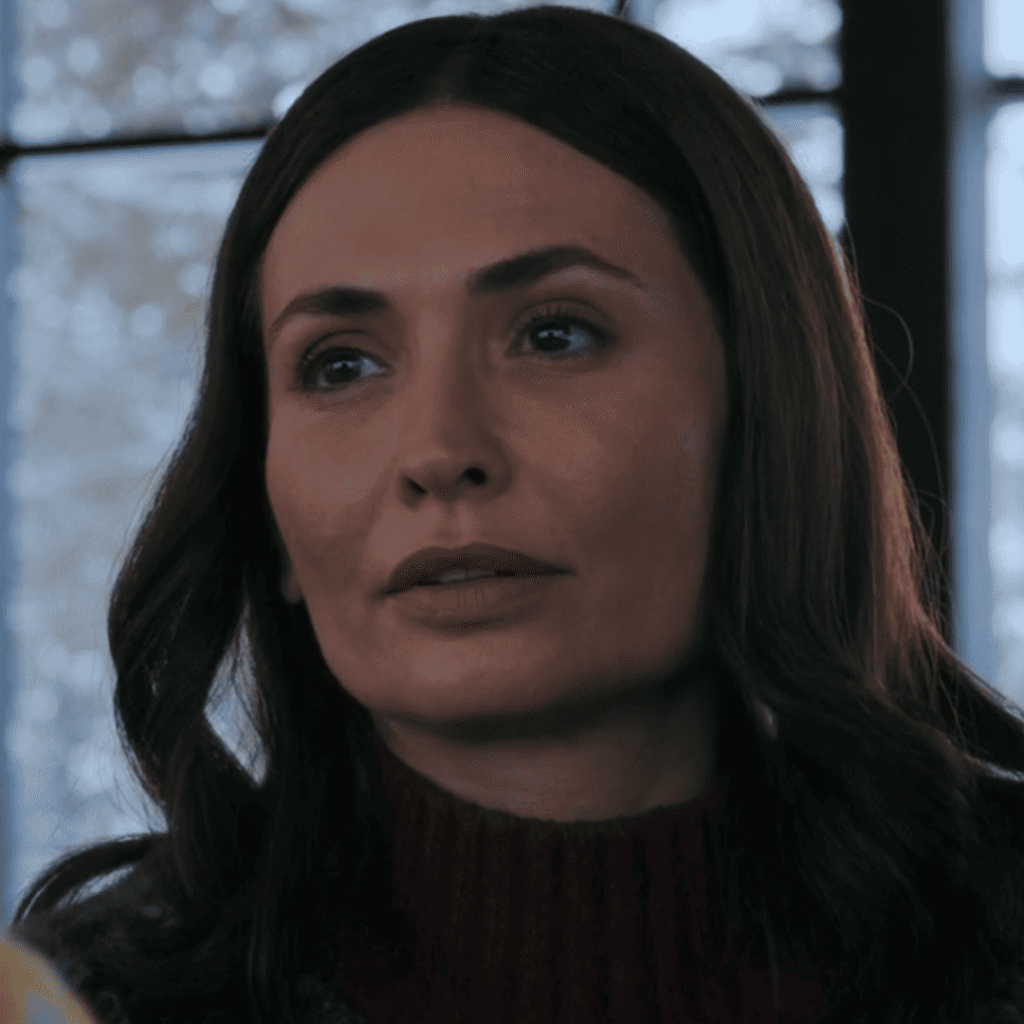 Pluribus Explained: Zosia spends quiet time with Carol inside the cabin, sitting close in shared stillness.