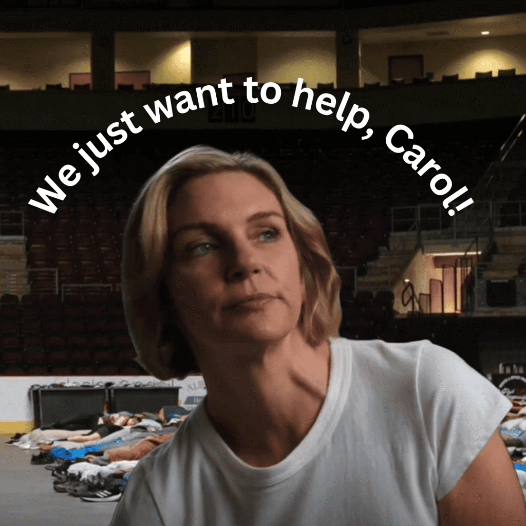 Pluribus Explained: Carol stands in the arena with the large message behind her that reads We just want to help, Carol.