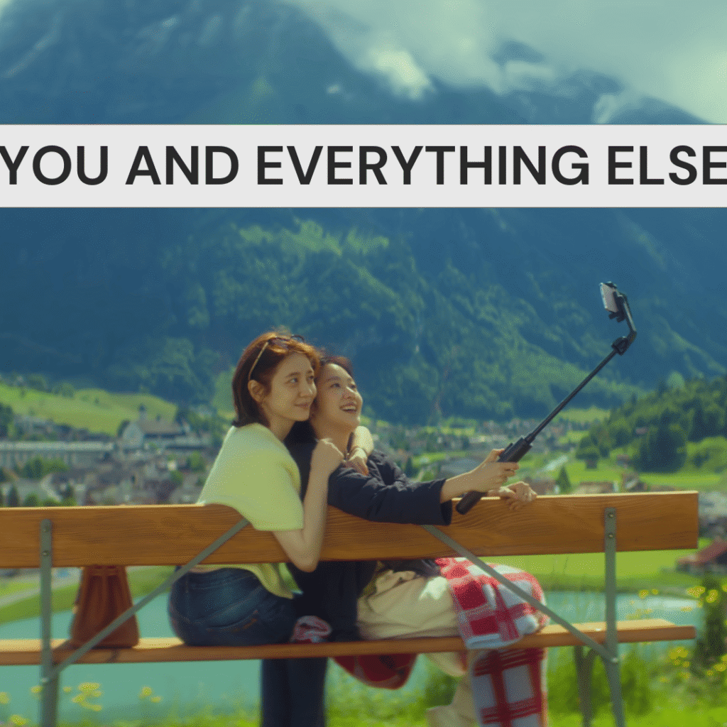 Eun-jeong and Sang-yeon smiling while taking a selfie together in Switzerland from You and Everything Else, one of the best Korean dramas of 2025.
