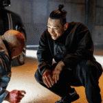 A tense still from the Bloodhounds Season 2 Review showing Im Baek-jeong crouching over the defeated In-beom after a brutal training session.