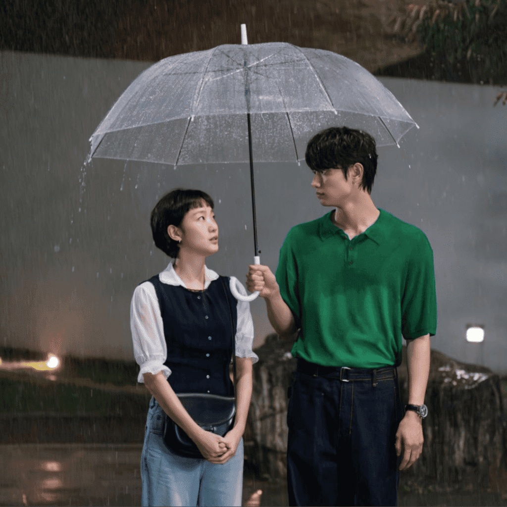 A cinematic still for the Yumi’s Cells Season 3 review showing Yumi and Soon-rok sharing an umbrella together in the rain.