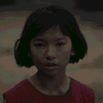 A character portrait still for the Straight to Hell review capturing a close-up of Kazuko Hosoki as a young woman before her rise to power.