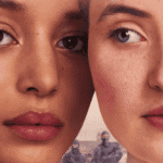 A promotional poster for The Testaments Review featuring Daisy and Agnes standing side by side.