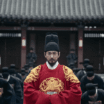 Still shot from The East Palace mid-season review showing the King dressed in ornate traditional royal regalia during the Queen Dowager’s 70th anniversary celebration.