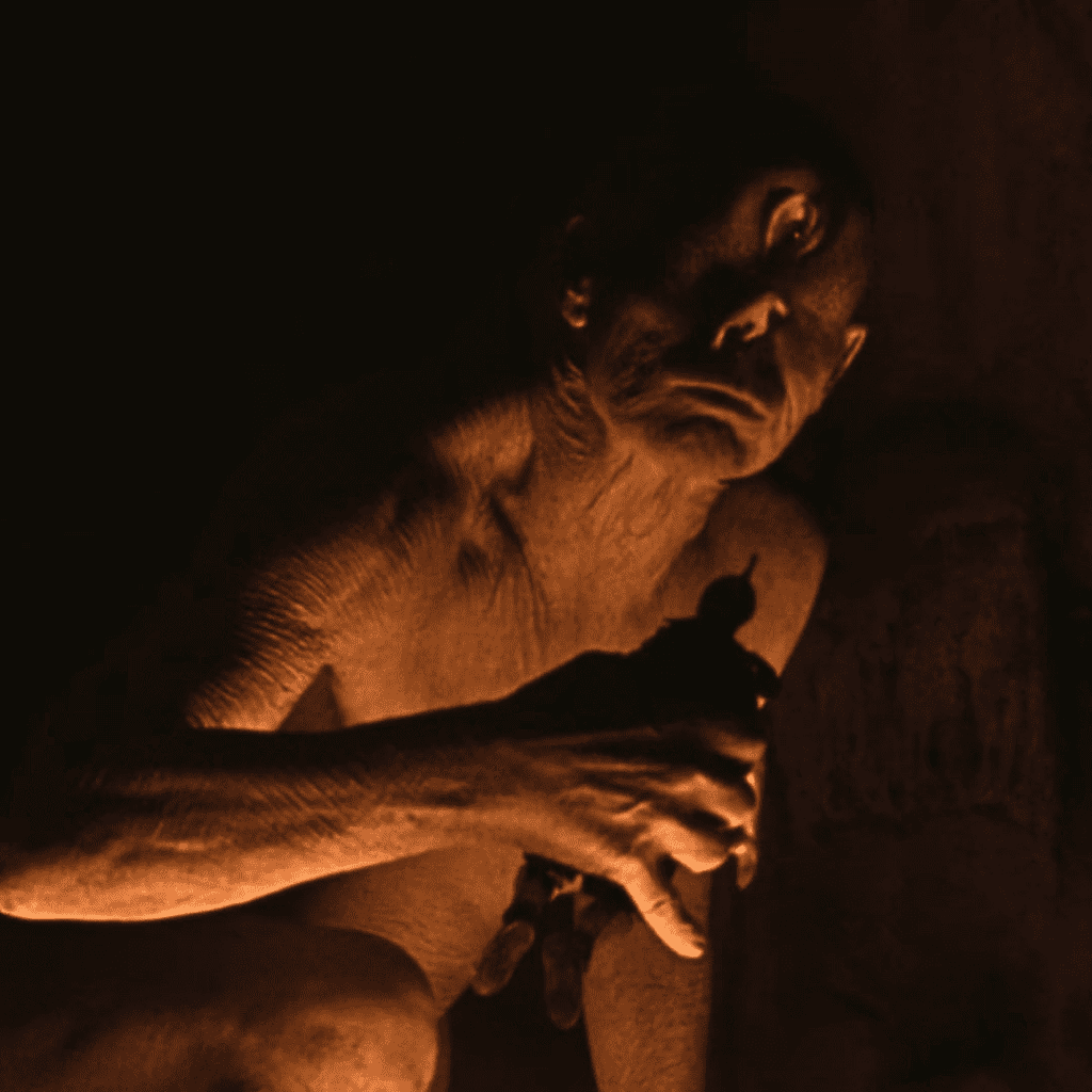 The terrifying Cyclops holding one of Odysseus' men in a pivotal monster scene from The Odyssey movie review.