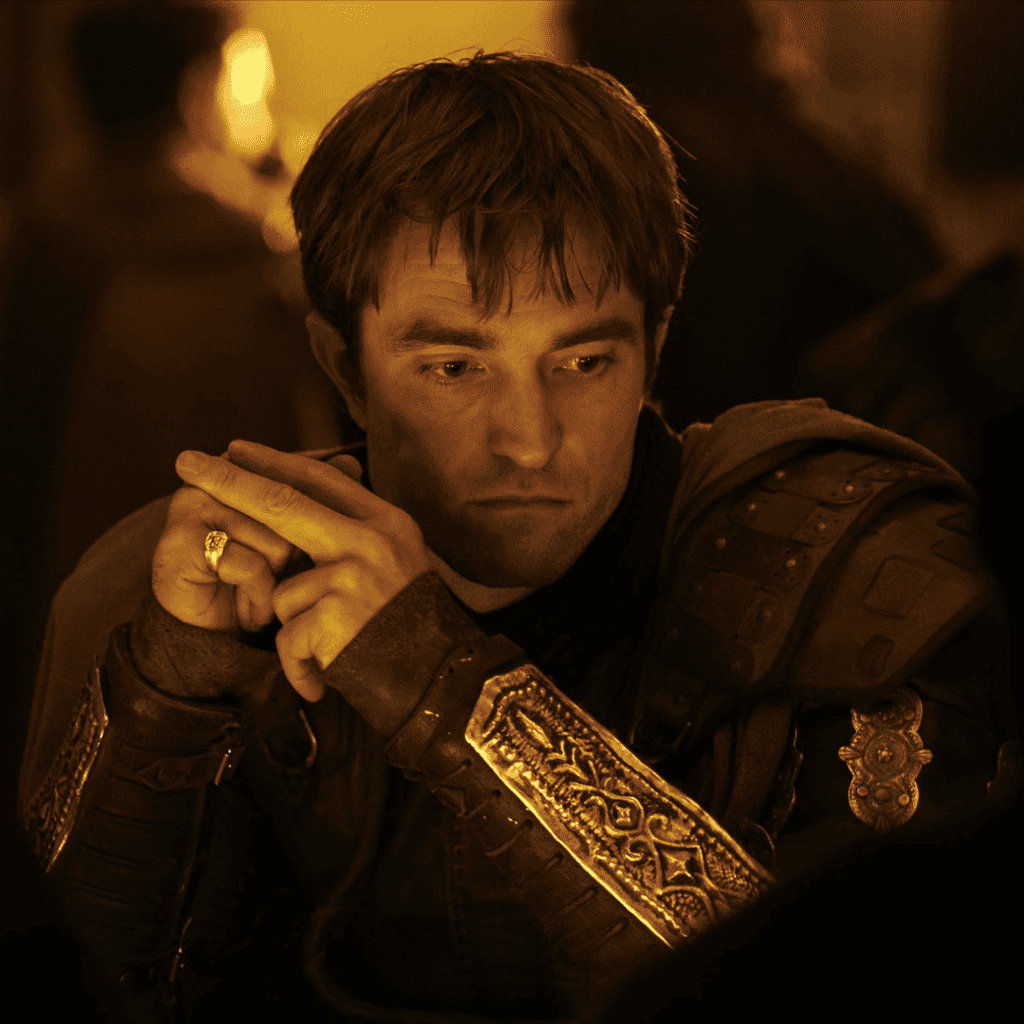 Robert Pattinson's character sitting in deep contemplation in Odysseus' house from The Odyssey movie review.