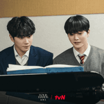 Official tvN still of Kang Pi-o and Choi Jeong-yo sitting side by side at a piano in school uniforms and reading sheet music in Four Hands, Two Sonatas.